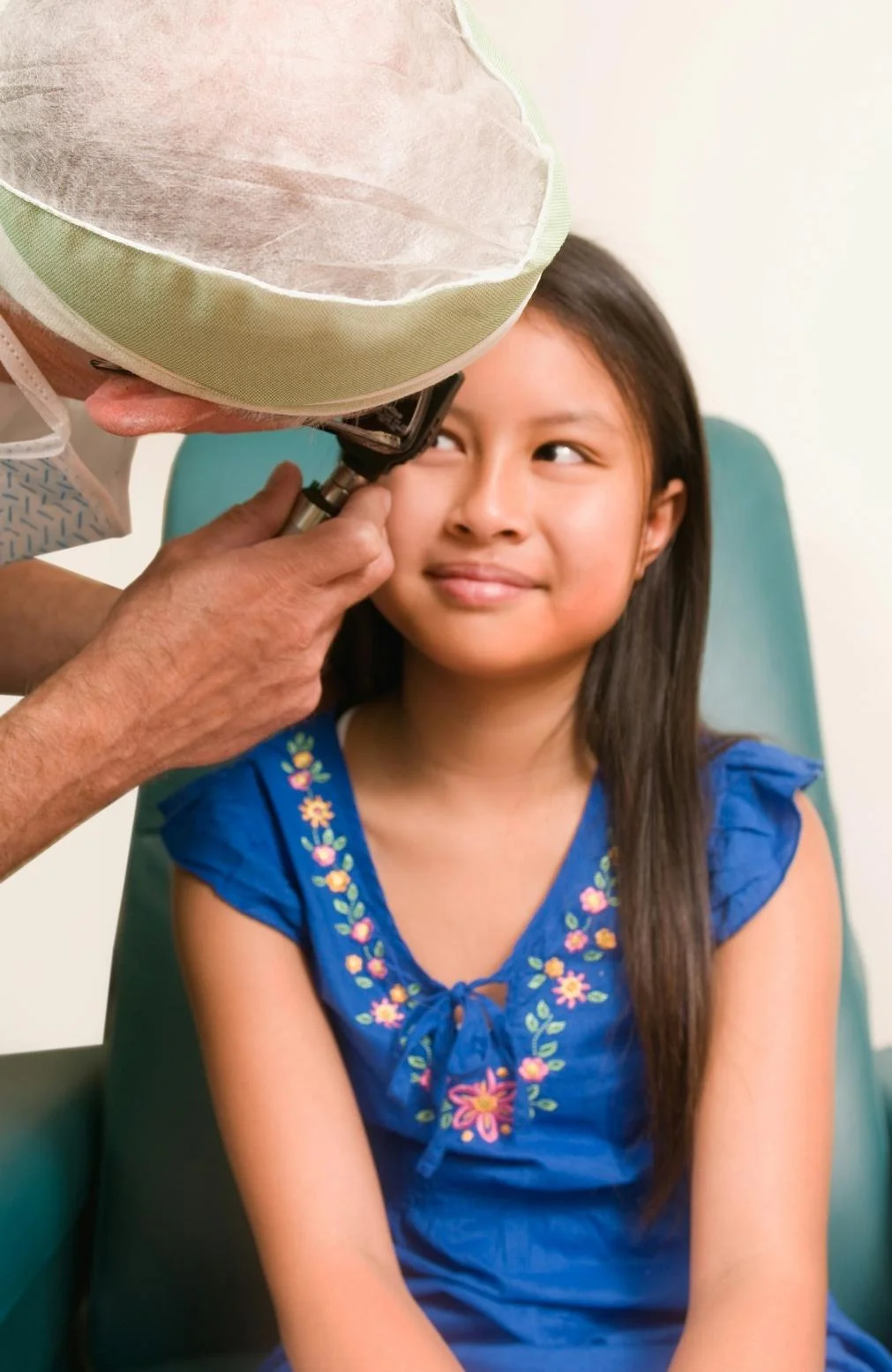 A young girl getting her eye checked by a doctor, possibly for pink eye