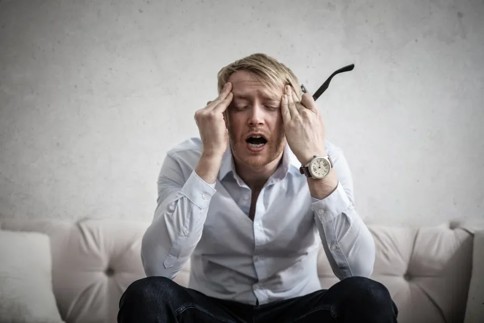 An image of a man touching his head in pain