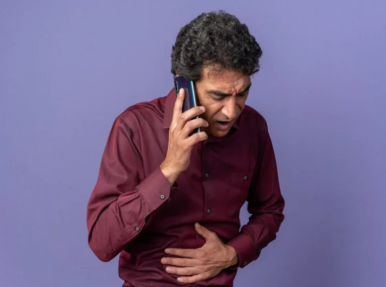 Man holding his stomach in discomfort due to GERD.