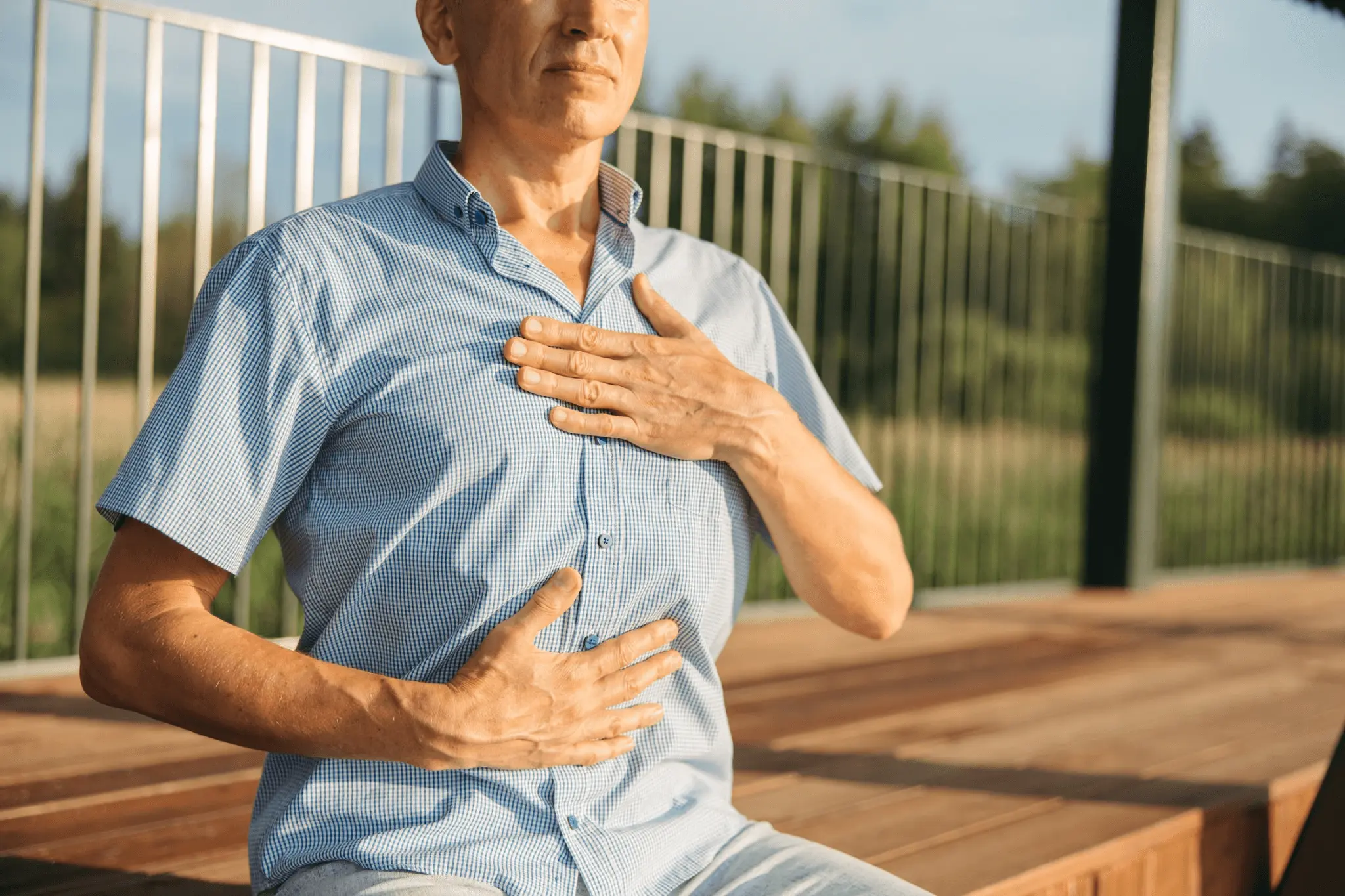 A man experiencing acid reflux in a park