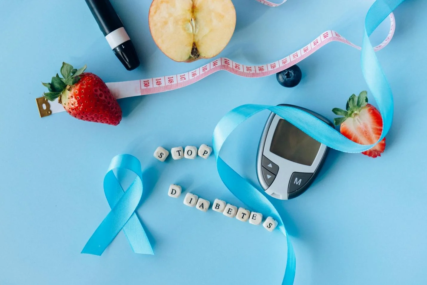 A glucometer, an apple and two strawberries symbolizing awareness for Diabetes