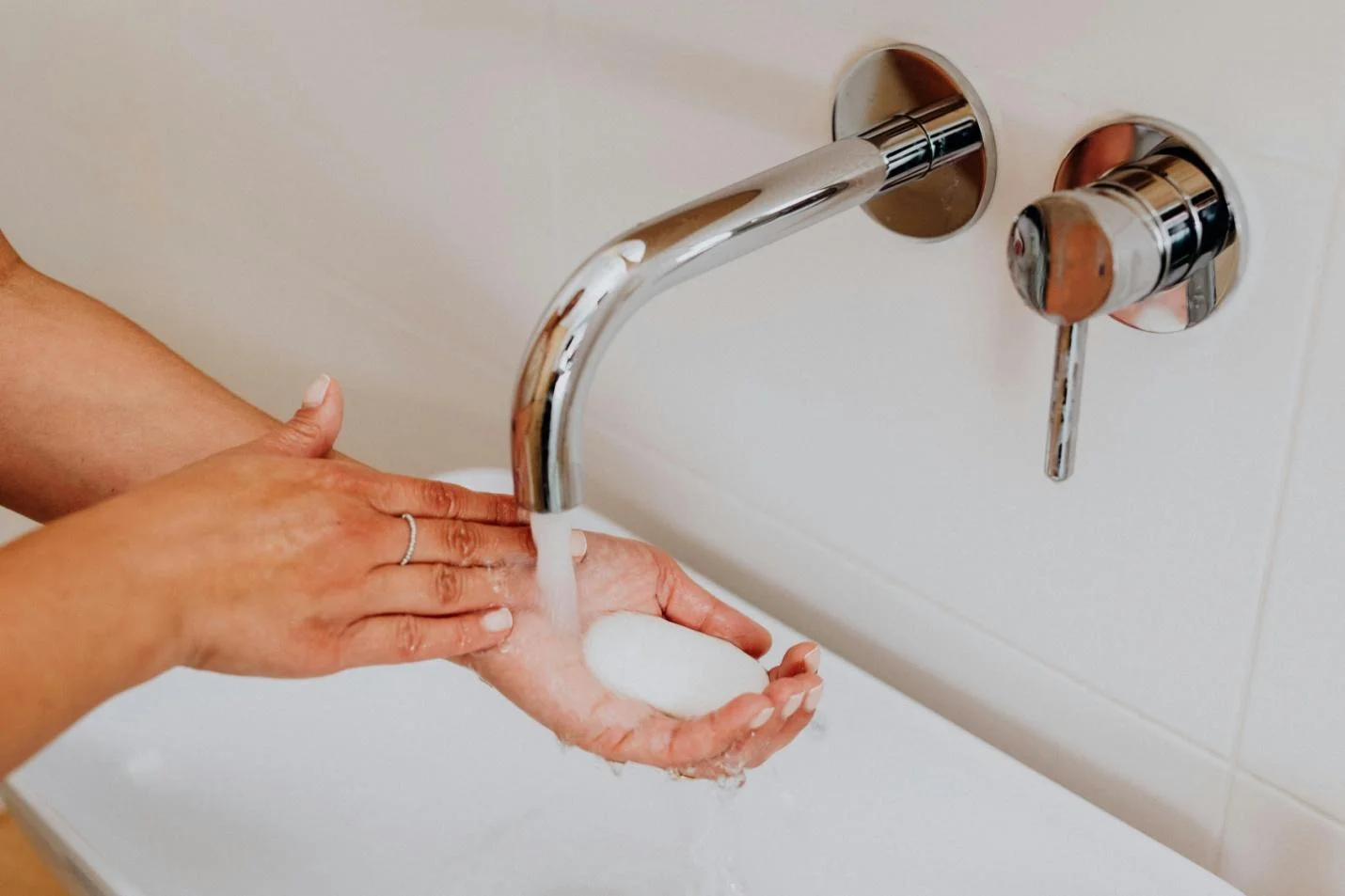  A female washing her hands with soap to prevent UTIs