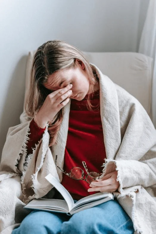 A woman rubbing her eye, indicating discomfort from an eye infection.