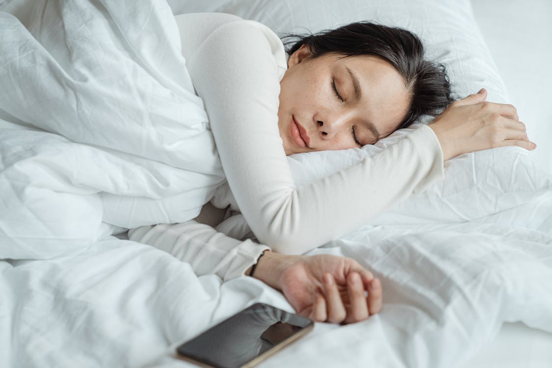 A woman sleeping peacefully with her smartphone by her side