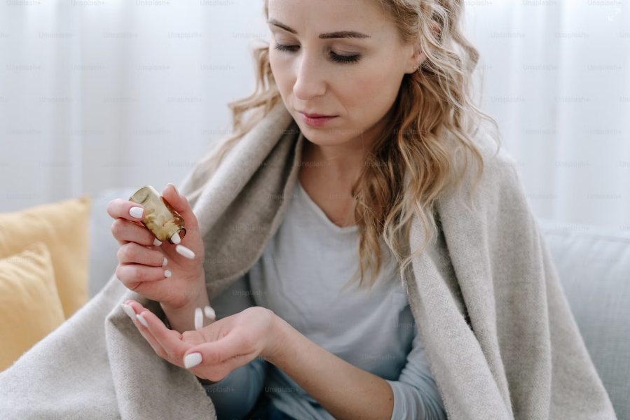 woman taking out pills in her palm