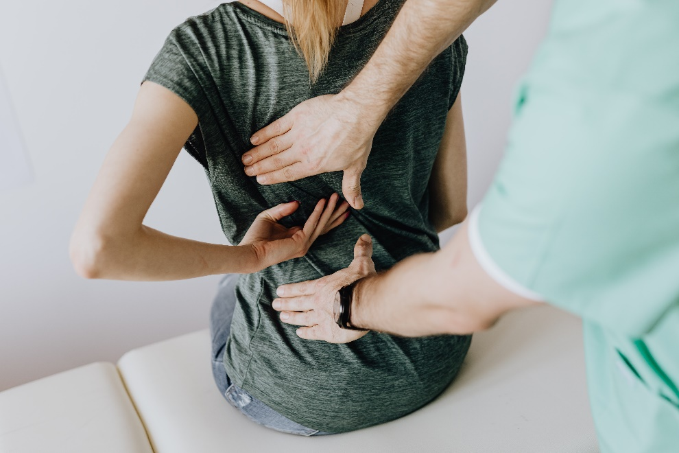 Doctor examining a woman’s aching back