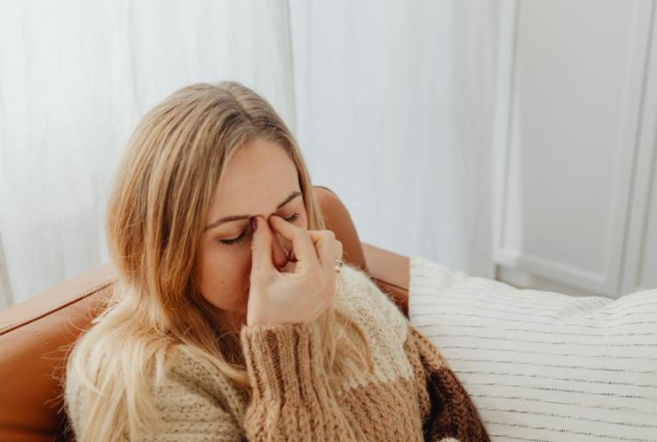 A woman is experiencing a headache because of sinusitis