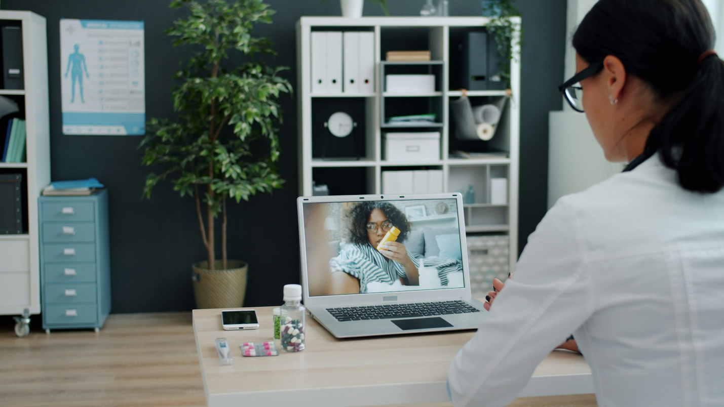 A doctor providing virtual treatment to a patient online.