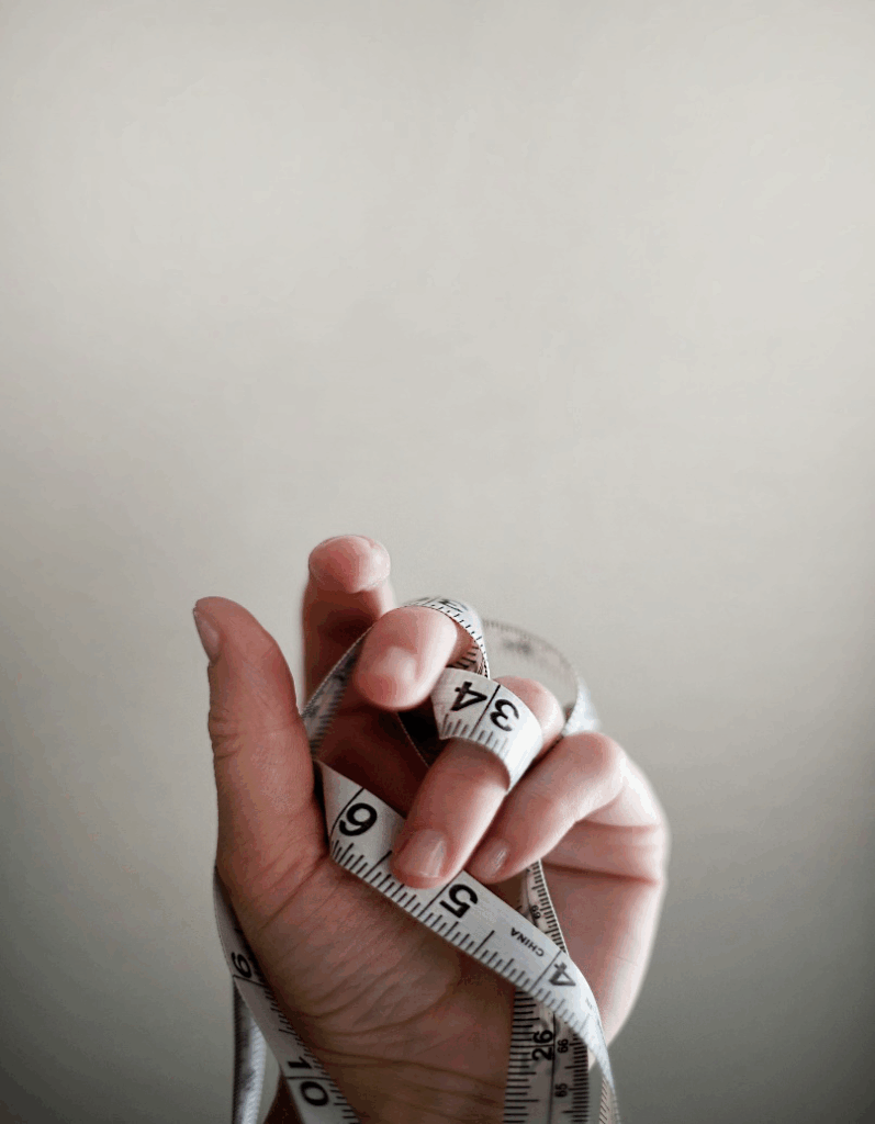 A person holding a measuring tape in their hands.
