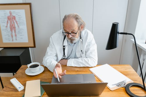 Online doctor explaining treatment plan during virtual video consultation on laptop