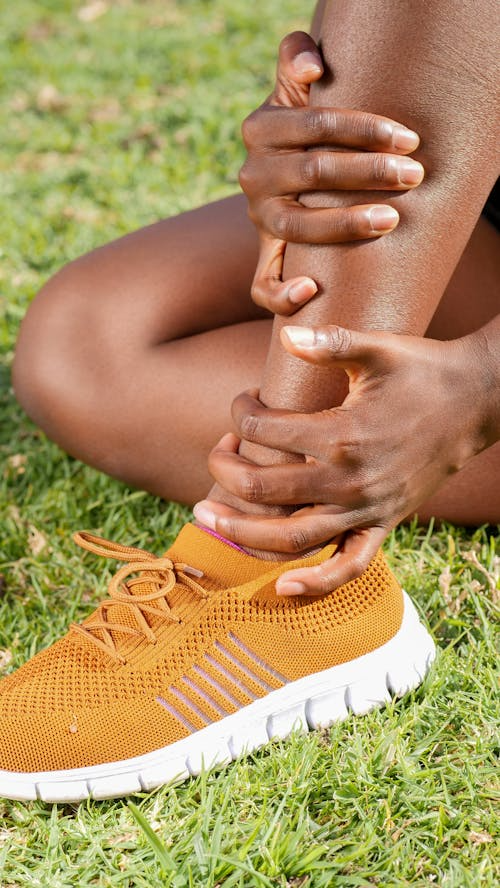 Person holding their ankle in pain due to a gout attack.