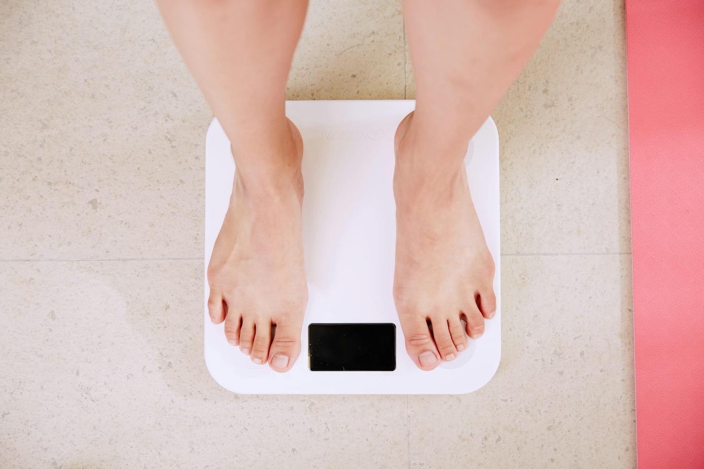 A person standing on top of a weighing scale.