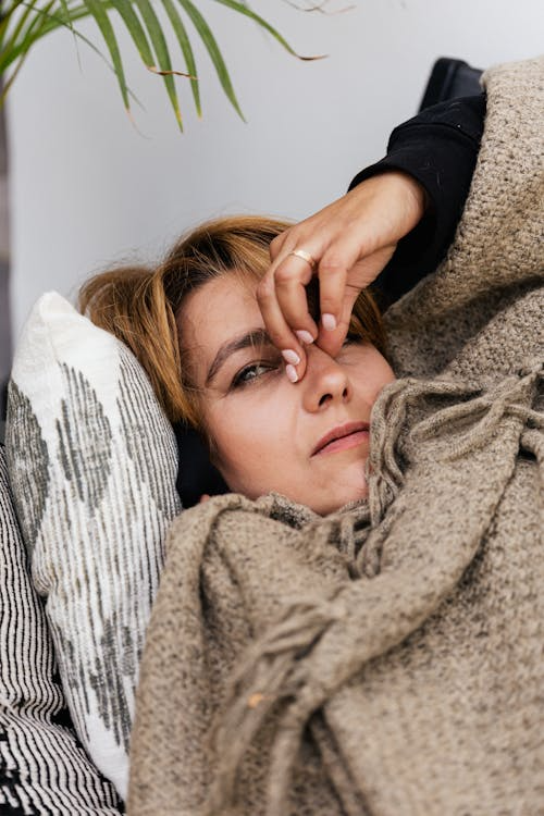 A woman looks unwell in bed.