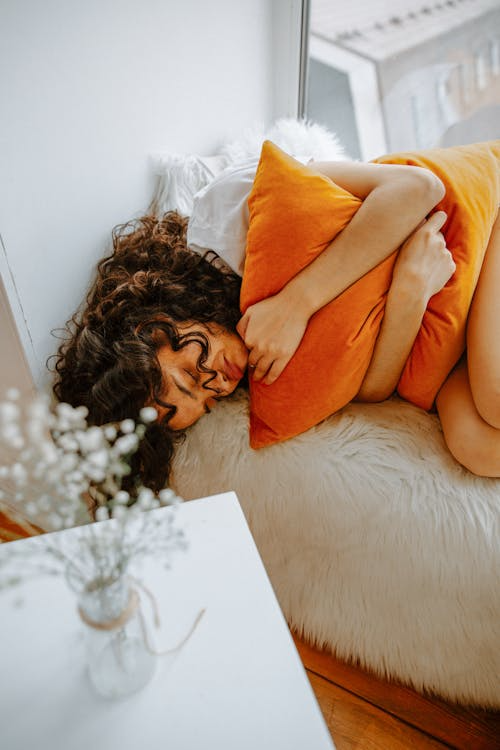 A woman with a sickness and body ache in bed.