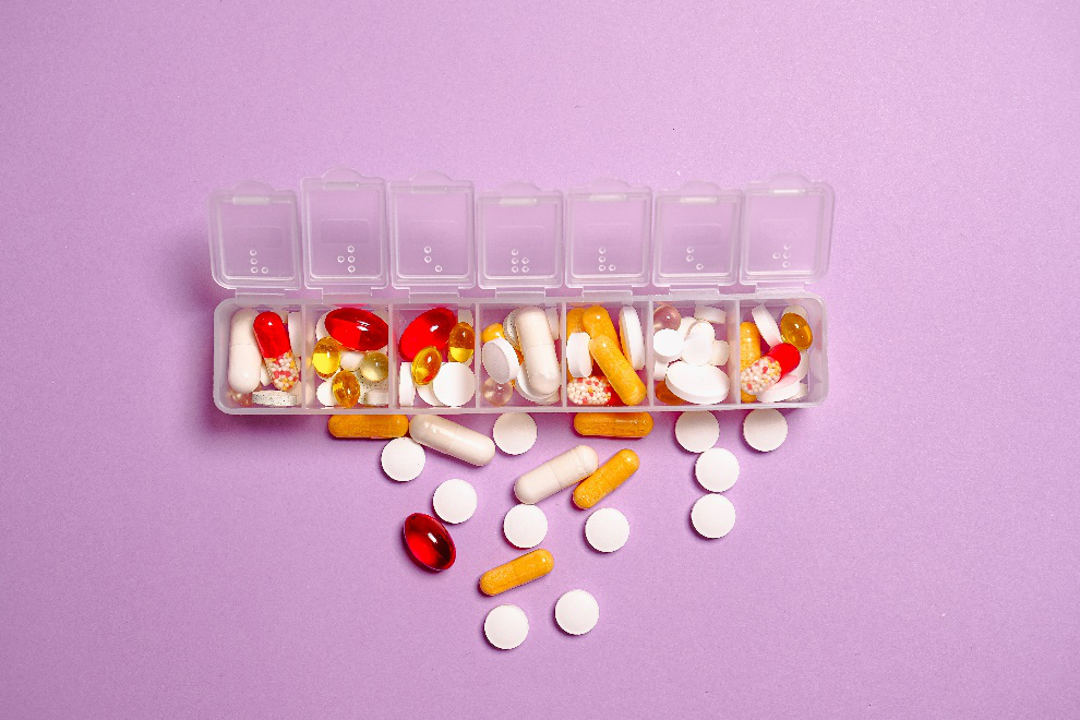 Close-up of medication pills on a white plastic container.