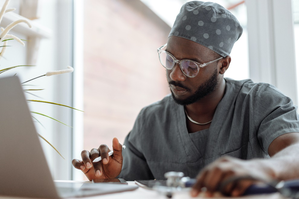 Medical practitioner using electronic devices to review patient information.