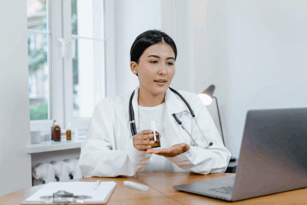 Woman holding a medicine bottle while consulting online.