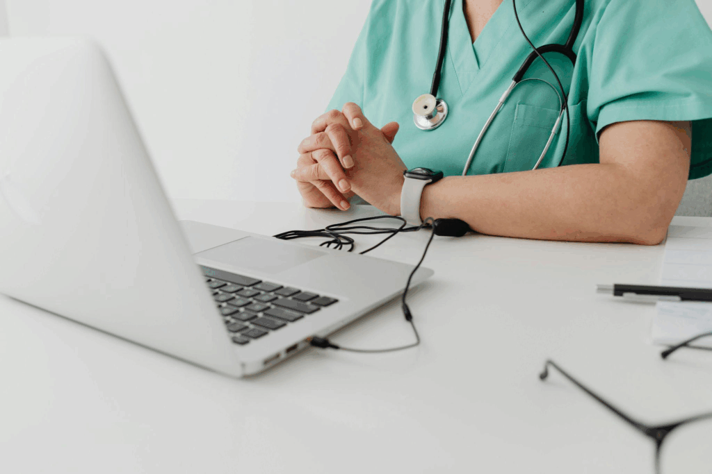 a doctor seated in front of a laptop for an appointment