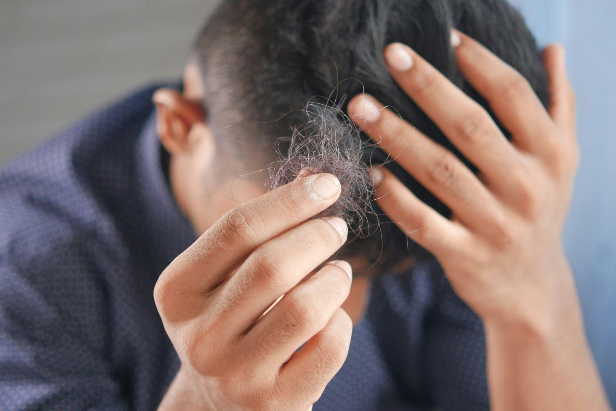 a person holding their broken hair in their hand