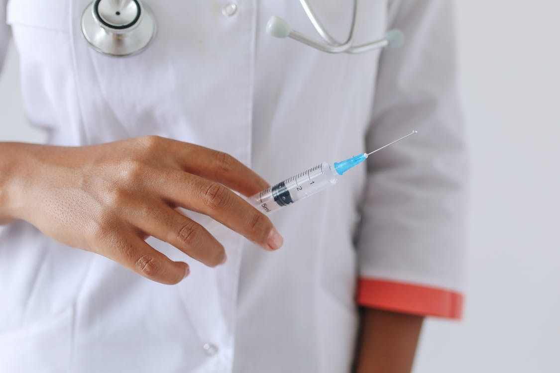 Doctor holding a syringe in his hands.
