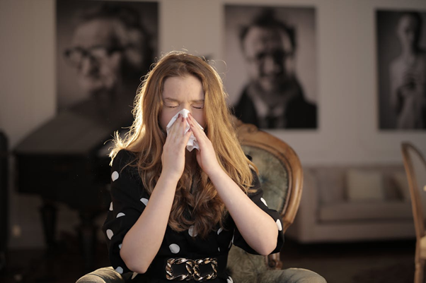 Sick woman wiping her nose with a tissue