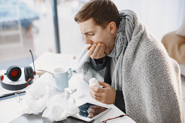 Sick man covering his mouth while coughing
