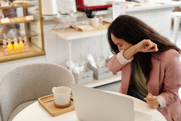 Sick woman covering her mouth while coughing