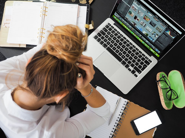 Woman sitting in front of a laptop appearing stressed