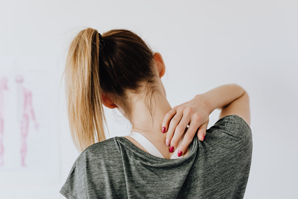 Woman touching her lower back while standing