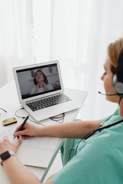 a doctor making a prescription for a patient having a sore throat during an online session