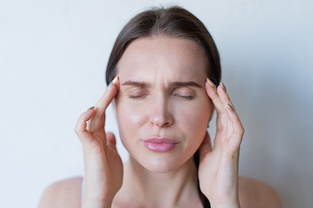 A woman holding her temples due to a headache.