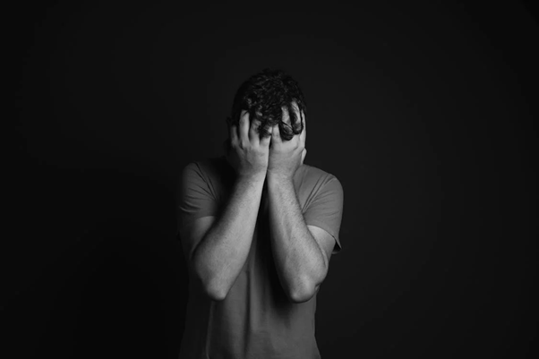 Man covering his face with his hands