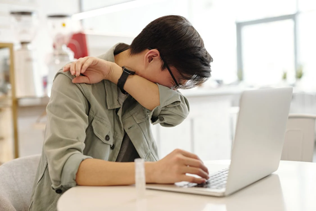 a sick man covering his mouth while sneezing