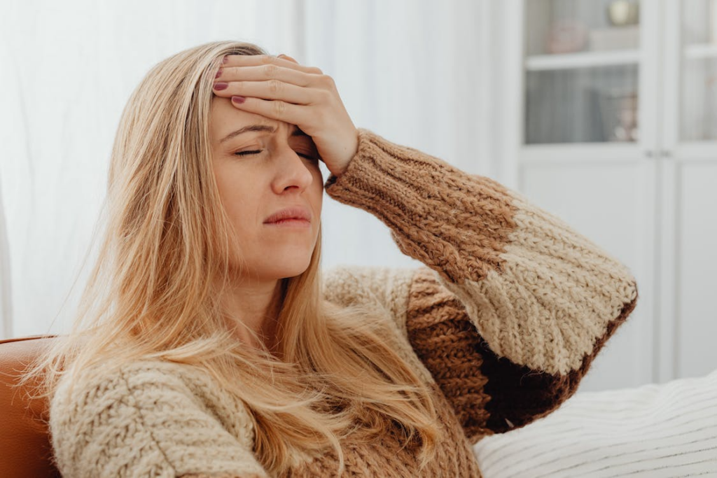 A woman holding her head due to an infection.