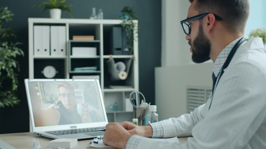 This image shows a doctor consulting a patient via video call on a laptop.