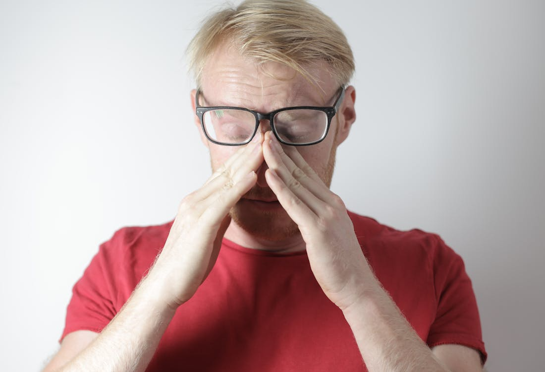 a person rubbing their irritated eyes.