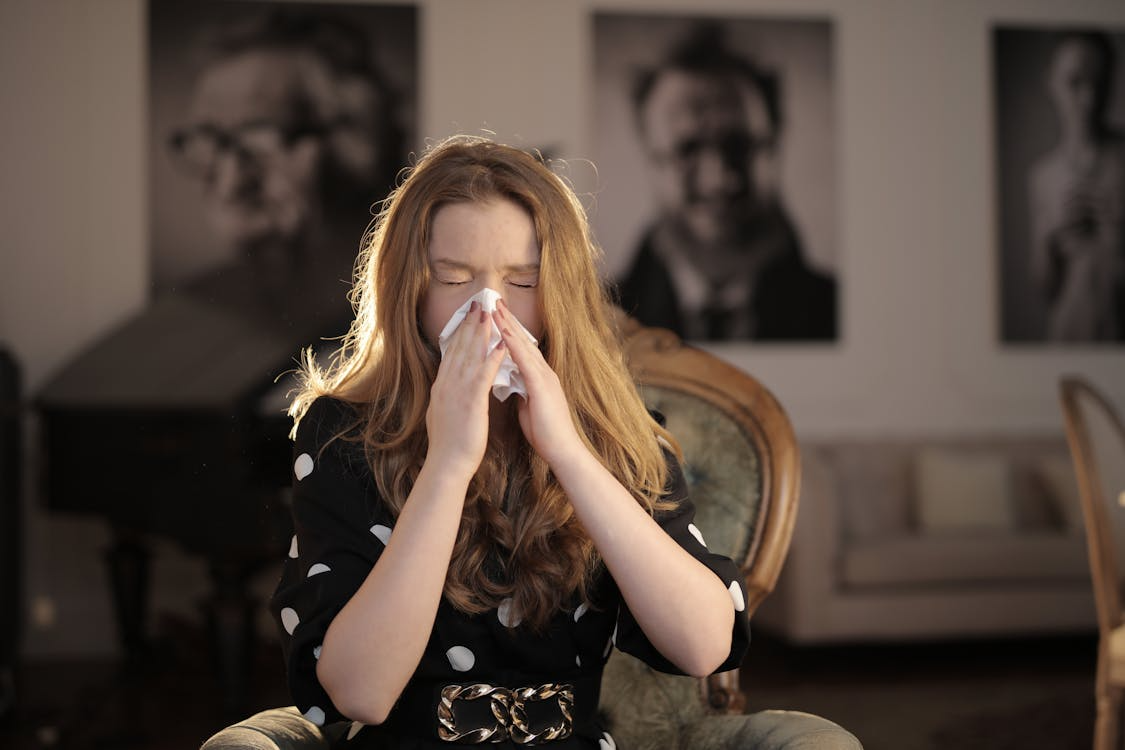 A person sneezing with their tissue.