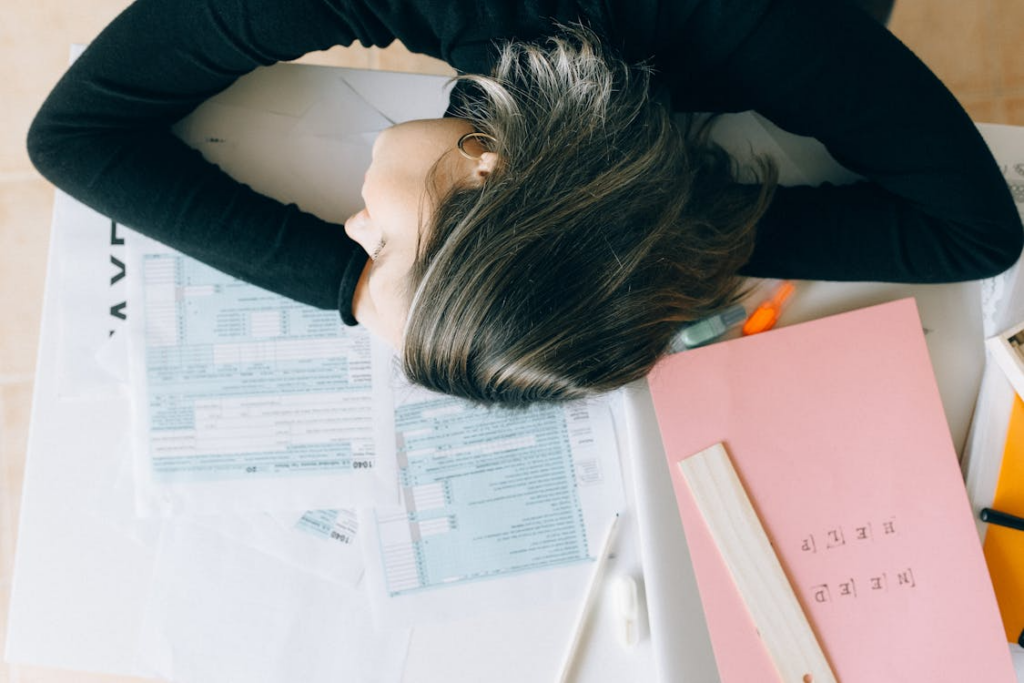 a woman working over a pile of papers and more. 