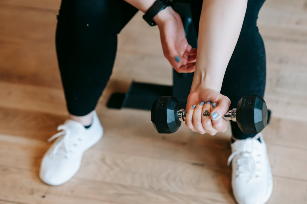 A woman carrying a dumb bell in their hands.