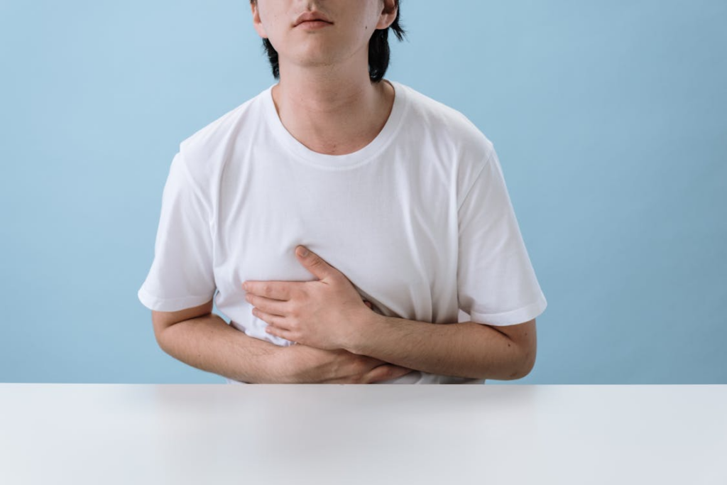 A person holding their stomach managing gut health. 
