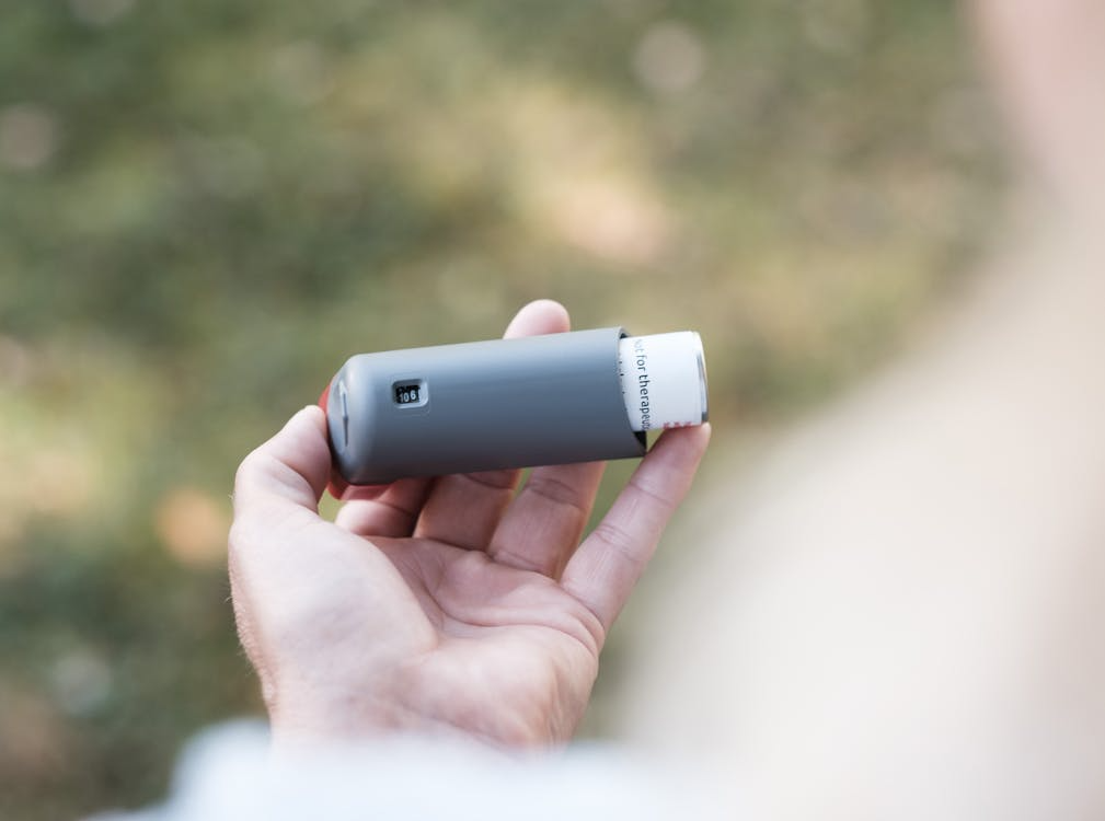 A person holding an inhaler in their hands. 