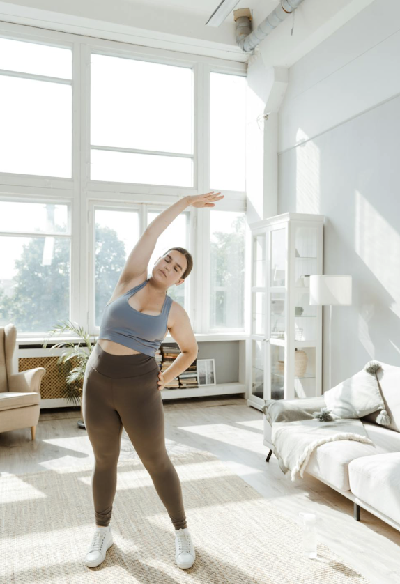 This photo shows a woman doing gentle stretching near a window