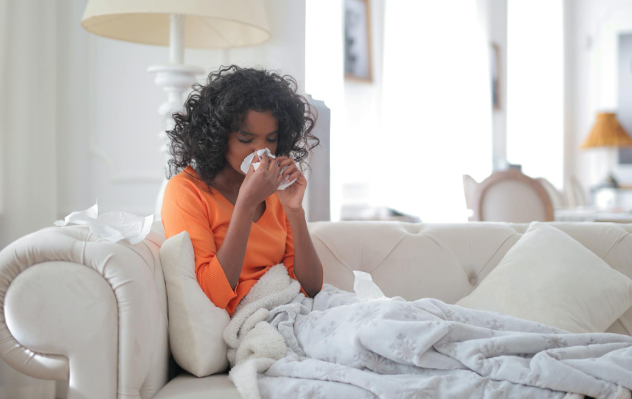  This image shows a woman wiping her nose with a tissue.