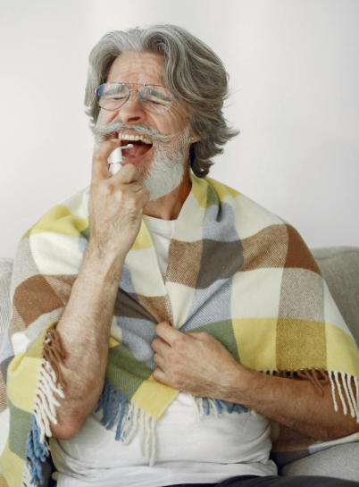 This image shows a sick elderly man spraying throat.