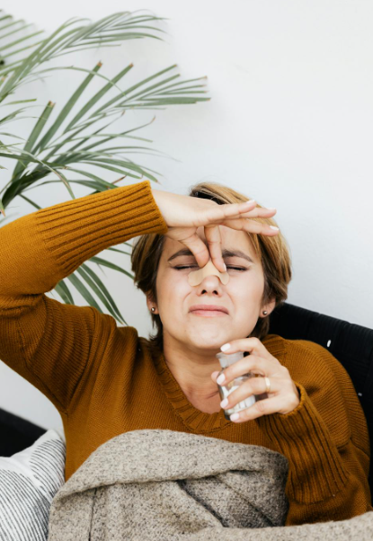 This image shows a woman holding the bridge of her nose.